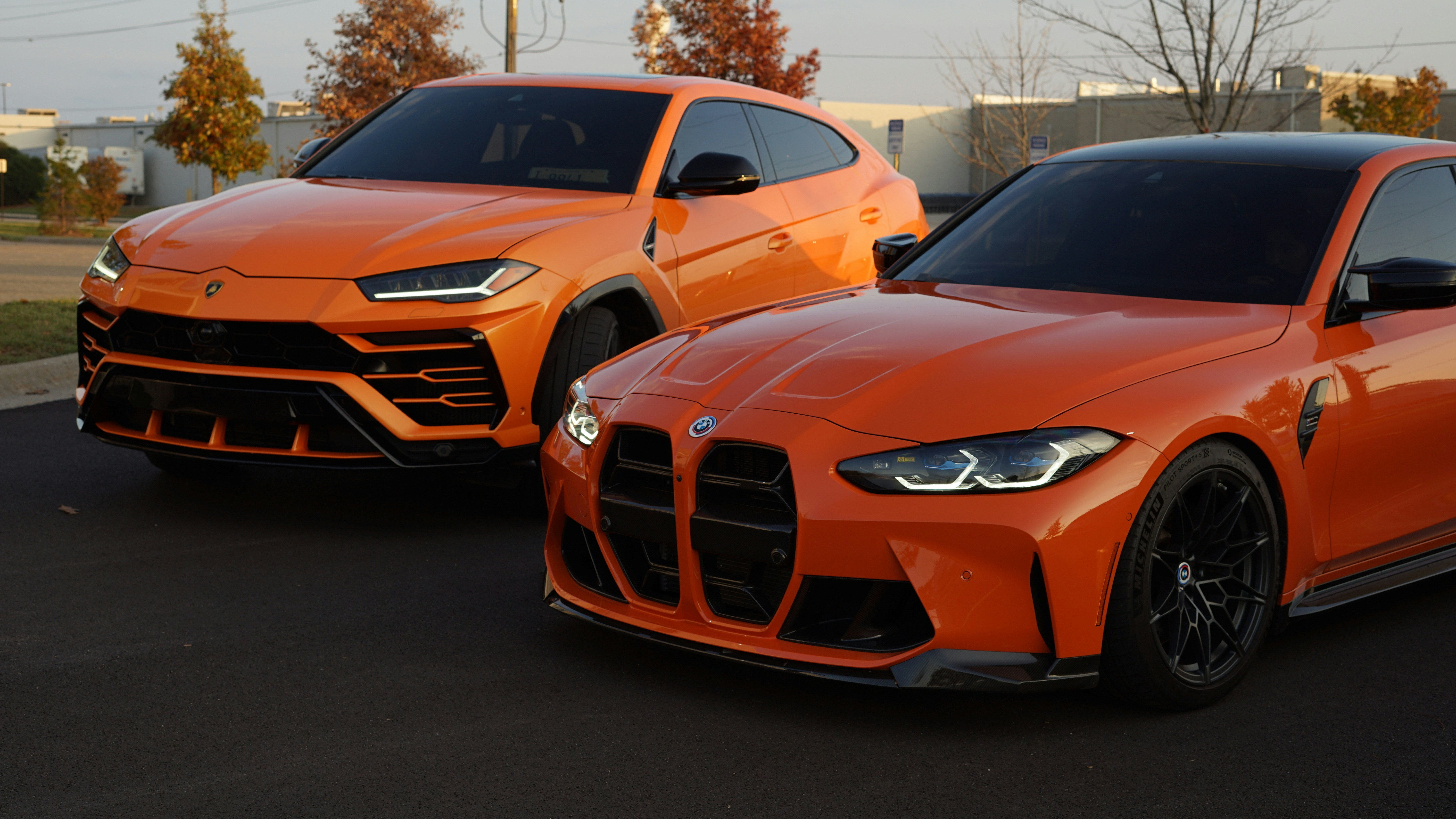two orange sports cars parked next to each other