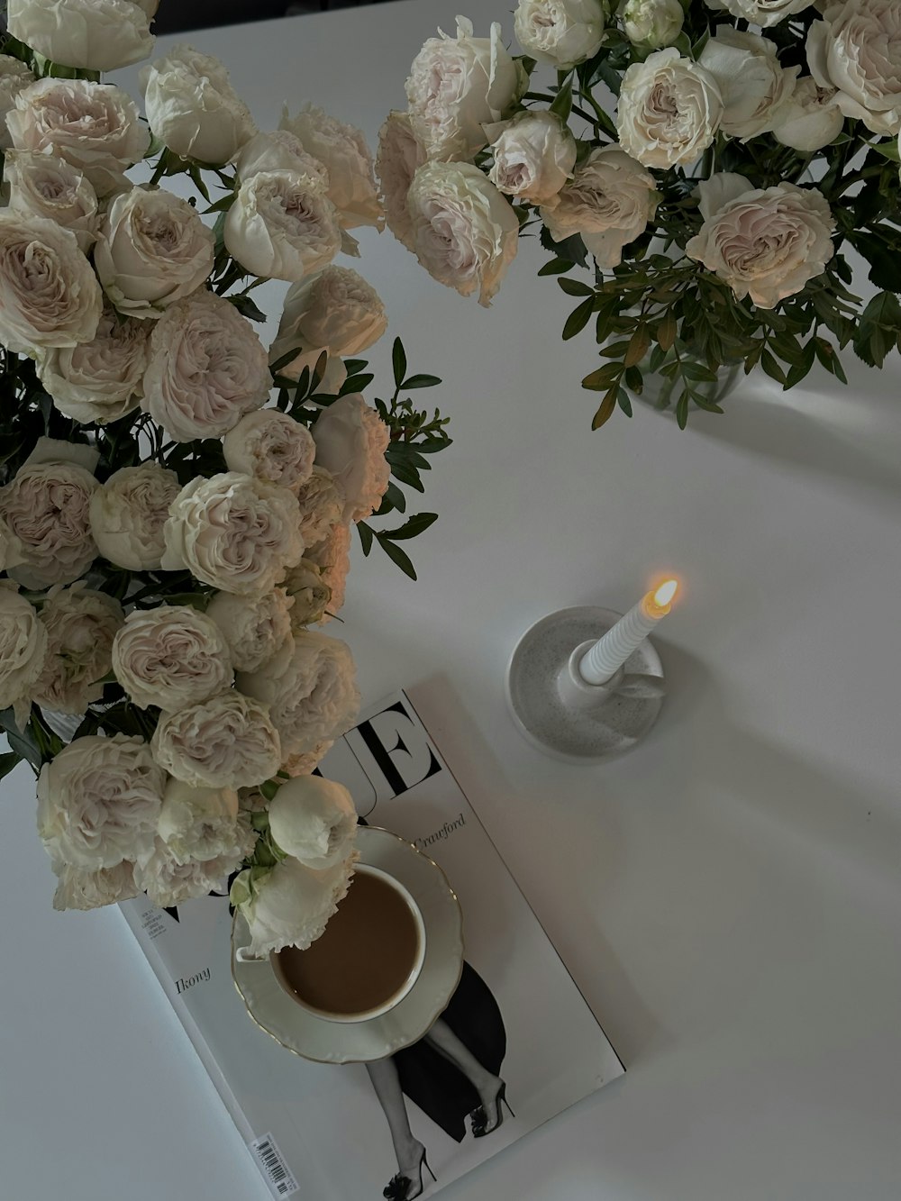 un vase avec des fleurs et une bougie sur une table