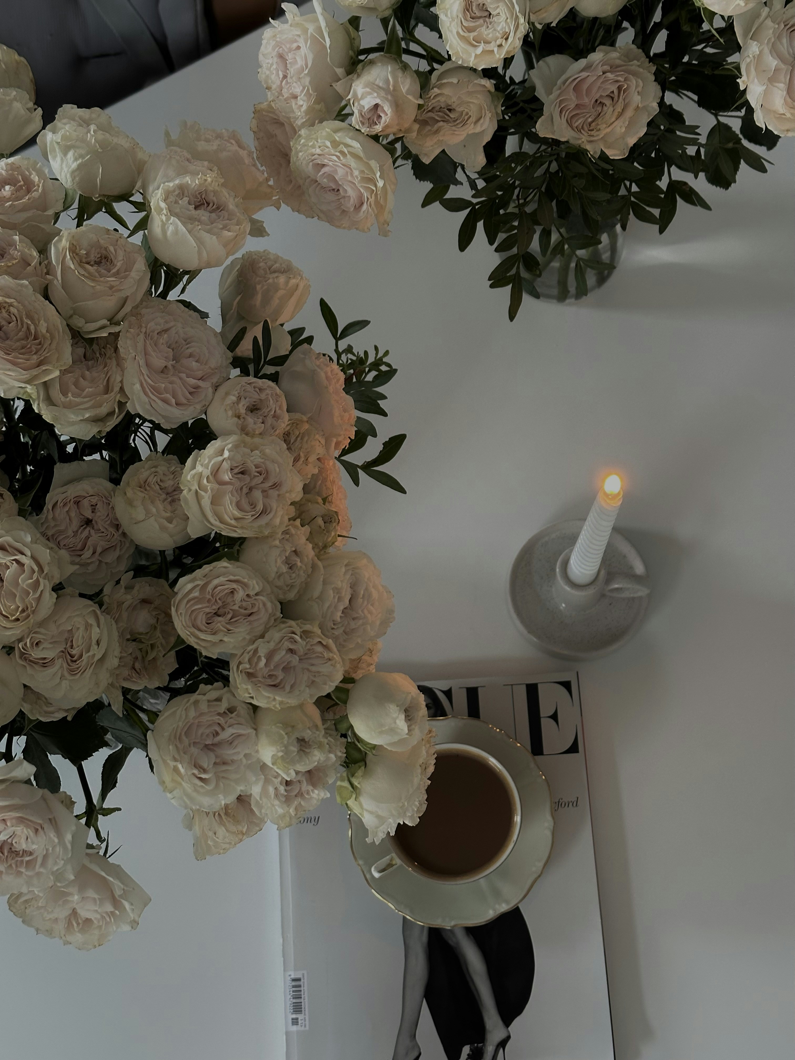 a cup of coffee and a candle on a table