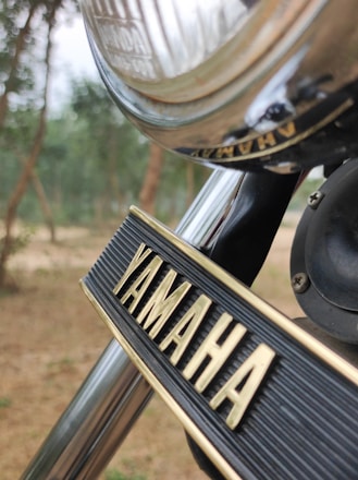 A friendly Yamaha service technician inspecting a sleek motorcycle in a bright, clean workshop.