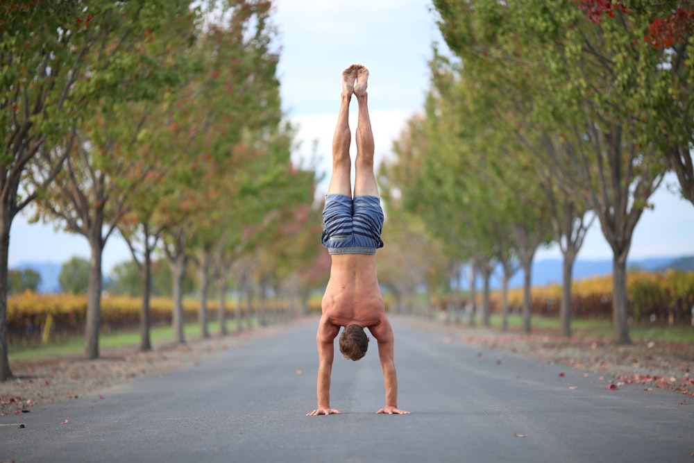 a person doing a handstand in the middle of a road