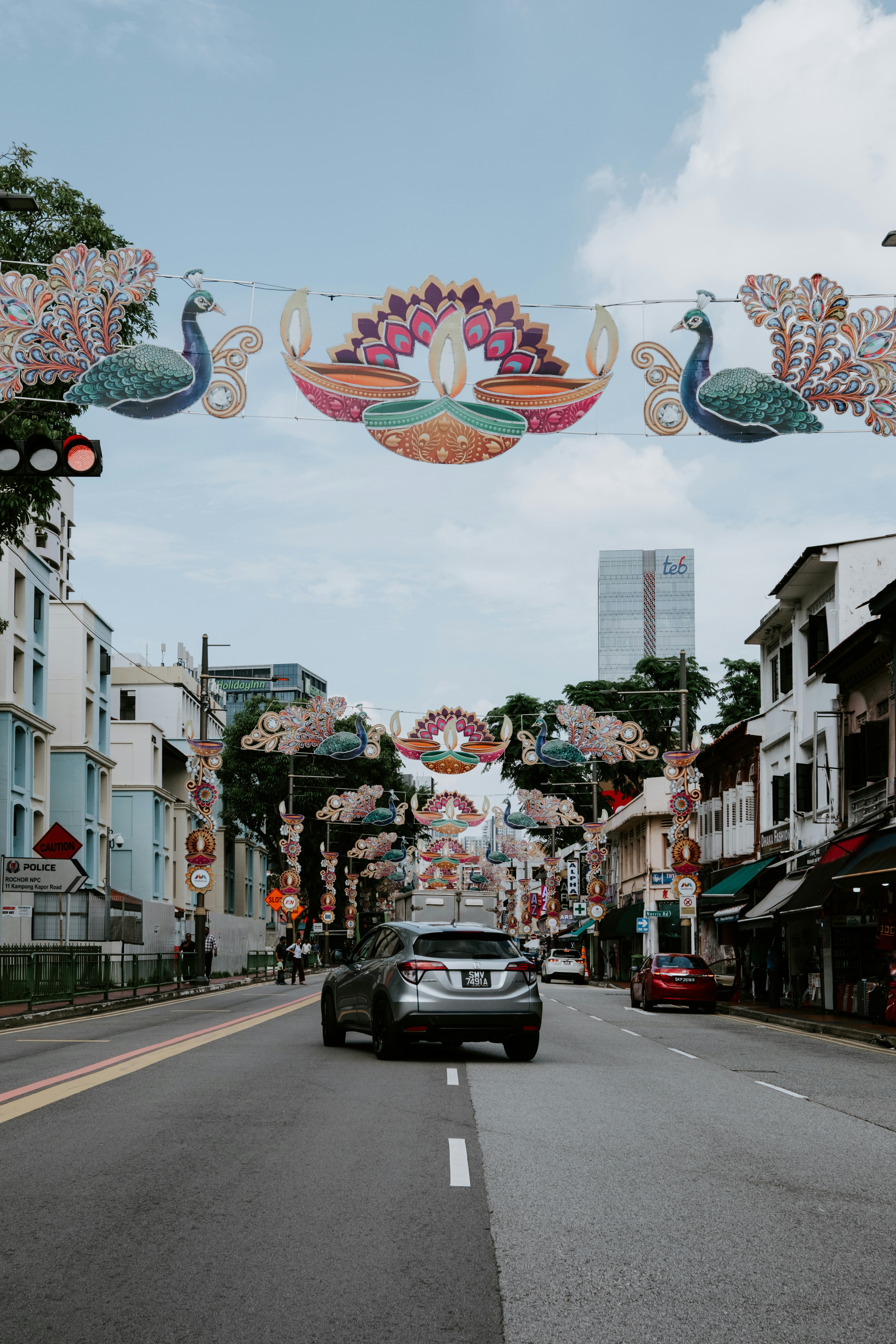 a car driving down a street under a decorated banner