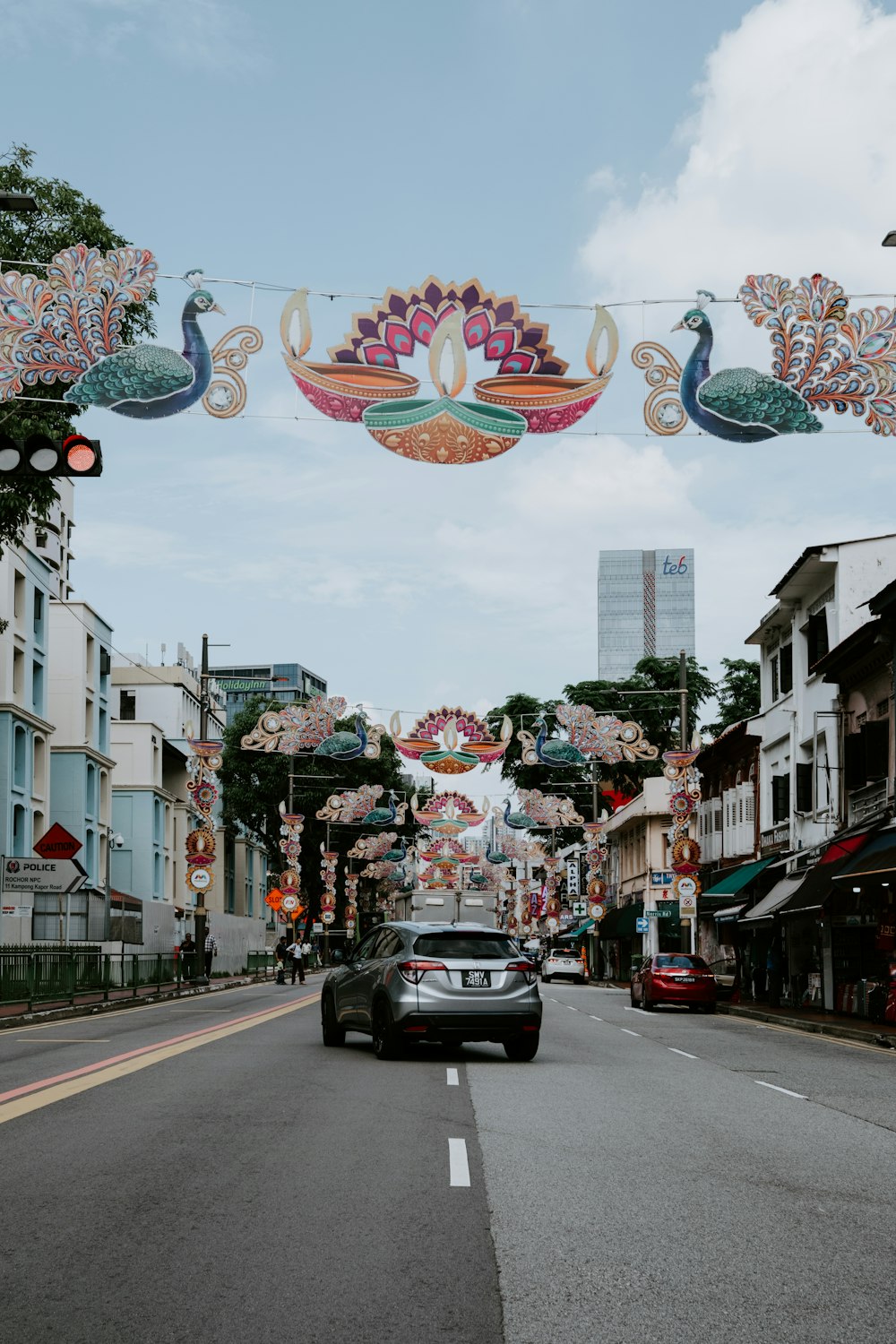 a car driving down a street under a decorated banner