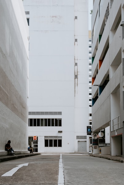 a person sitting on a bench in an empty parking lot