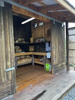 A cozy farm store shed displaying fresh farm products against the wide open prairie backdrop.