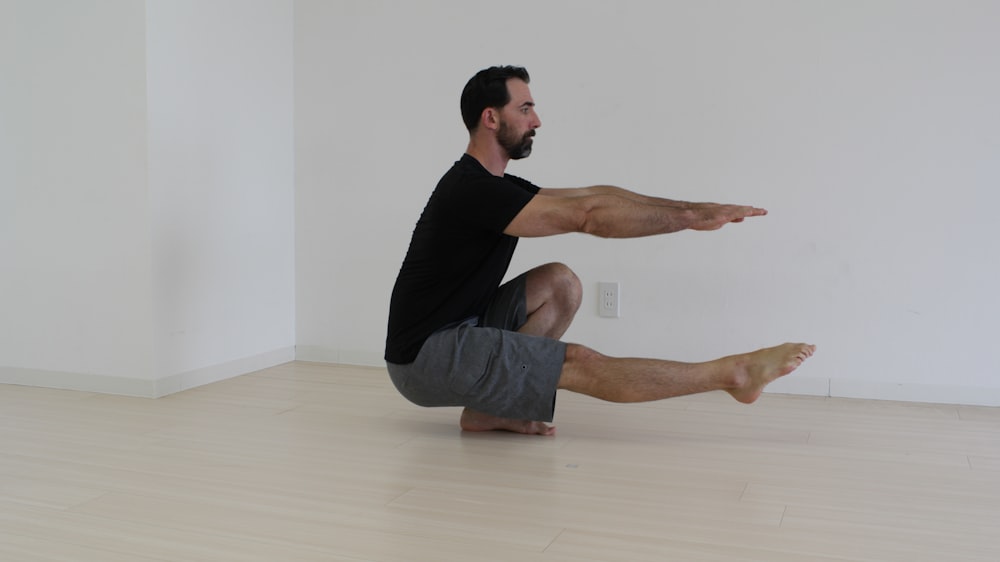 a man sitting on the floor stretching his legs