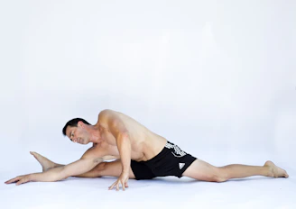 A man stretching in sleek gym wear inside a bright, modern fitness studio.