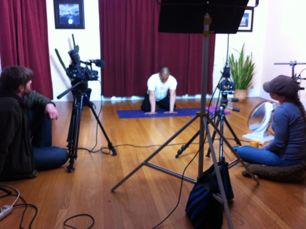 a couple of people sitting on the floor in front of a camera