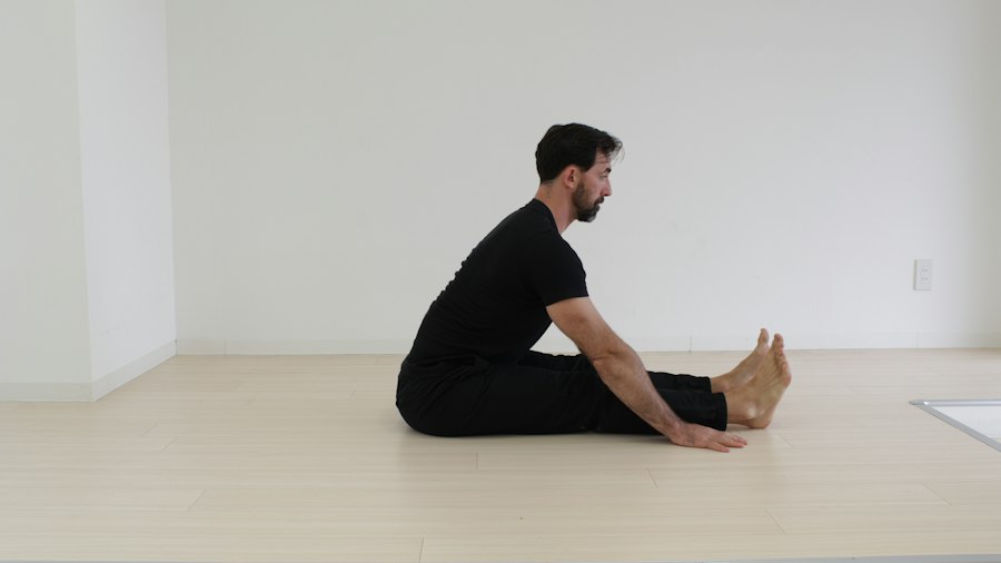 A member sitting on the floor of a bright training room between sets.