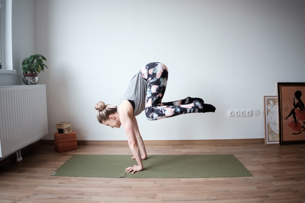 Une femme fait une pose de yoga sur un tapis