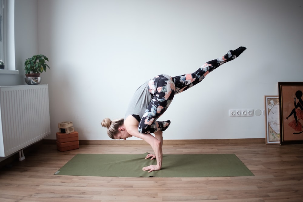 une femme faisant le poirier sur un tapis de yoga