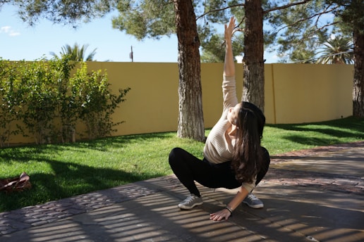 a woman doing a handstand in a yard