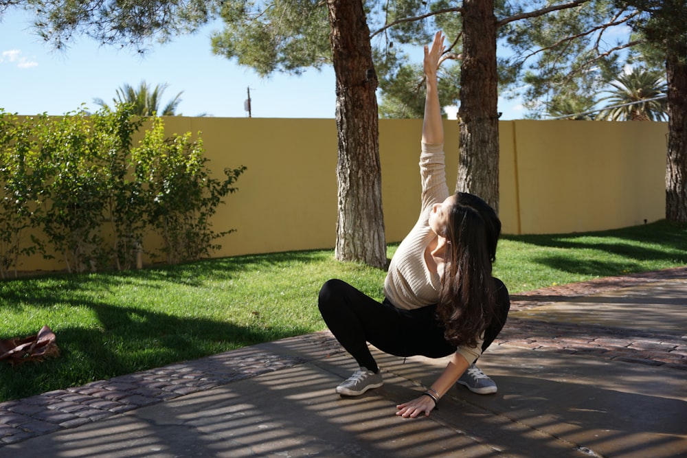 a woman doing a handstand in a yard
