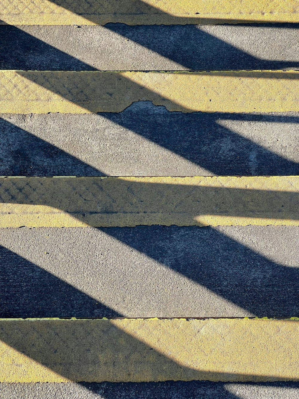 the shadow of a person walking down a sidewalk