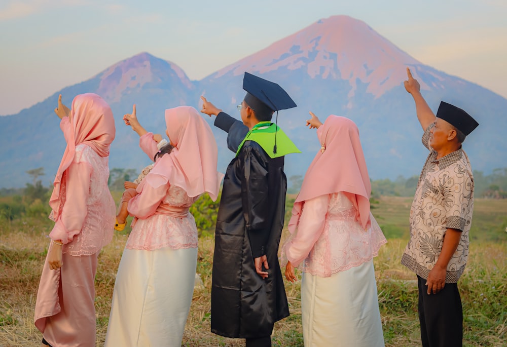 a group of people standing next to each other in front of a mountain