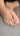 A close-up view of a foot resting on a gray fabric surface, showing detailed skin texture and nail features.