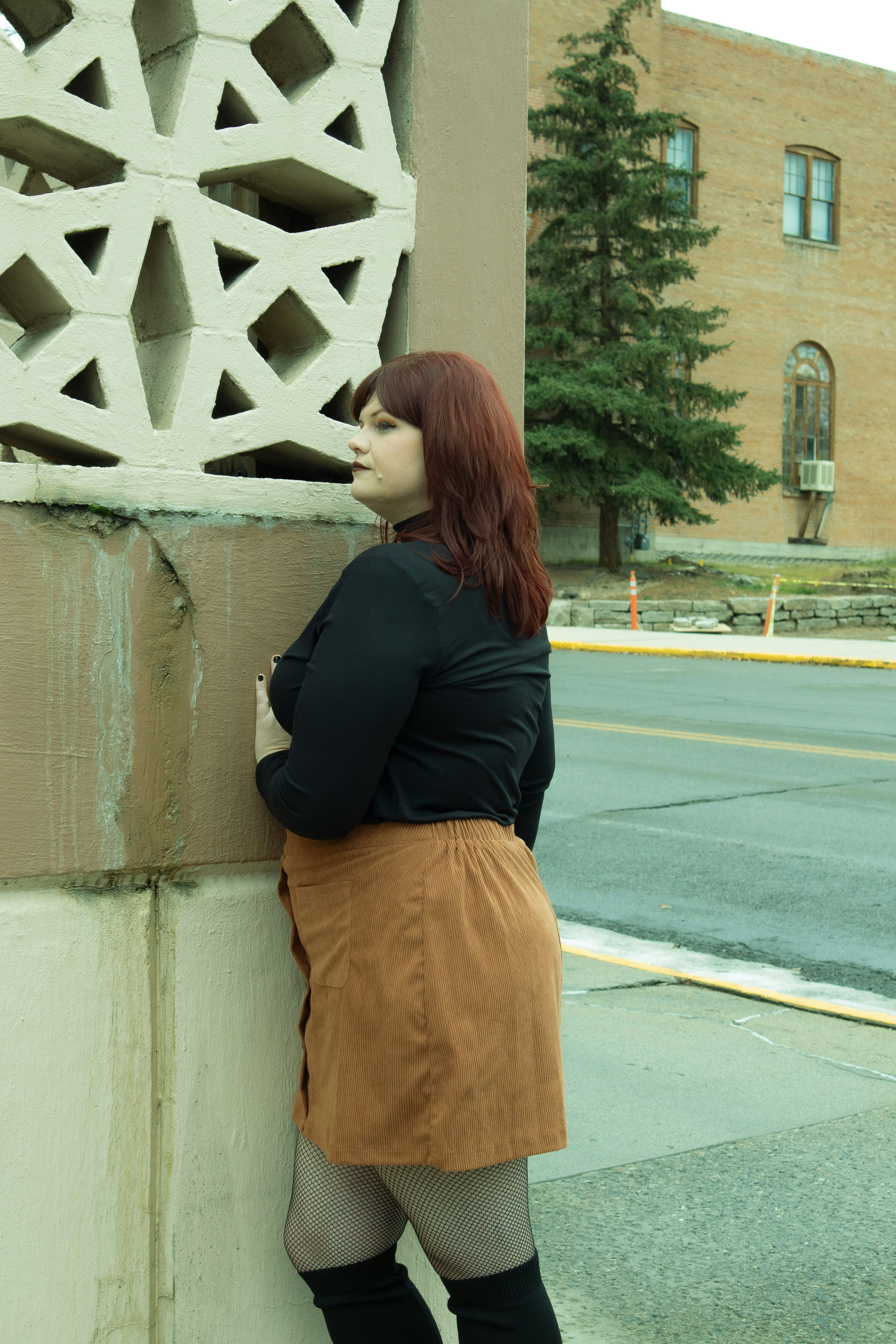 A woman leaning against a wall with her hands on her hips photo – Free ...