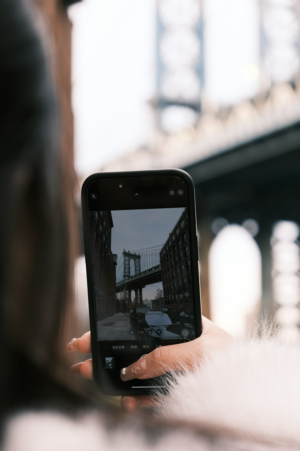 a woman is taking a picture of a bridge