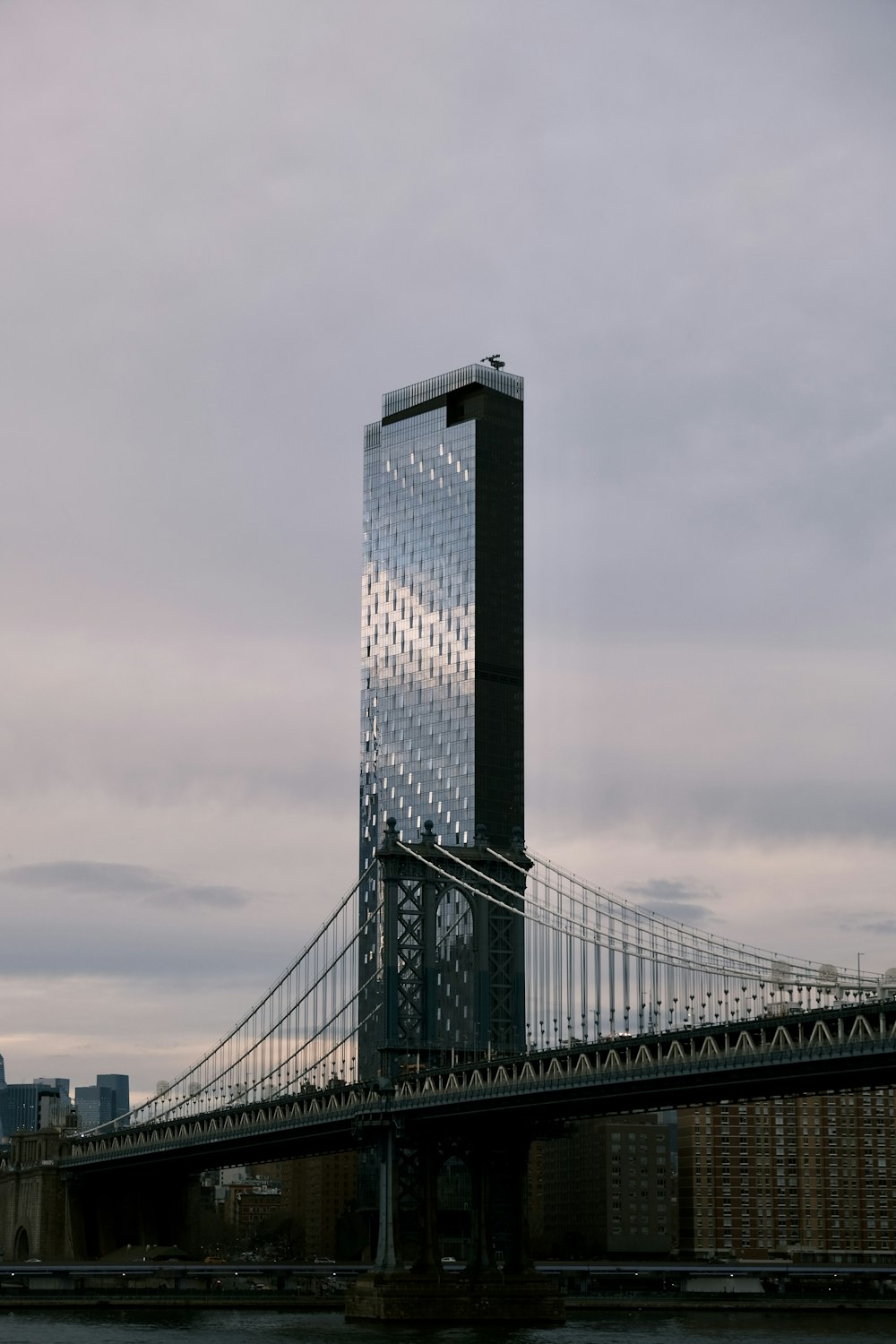 a very tall building sitting on the side of a bridge