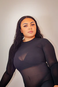 A sleek, minimalist photo of a model wearing a sharp, modern outfit from Elite Frieza Clothing, set against a neutral urban backdrop.