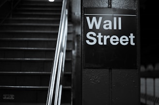 a black and white photo of a wall street sign
