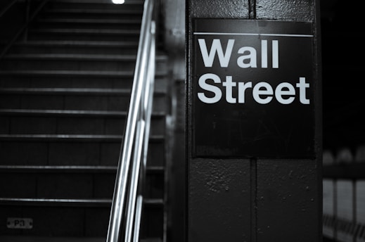 a black and white photo of a wall street sign