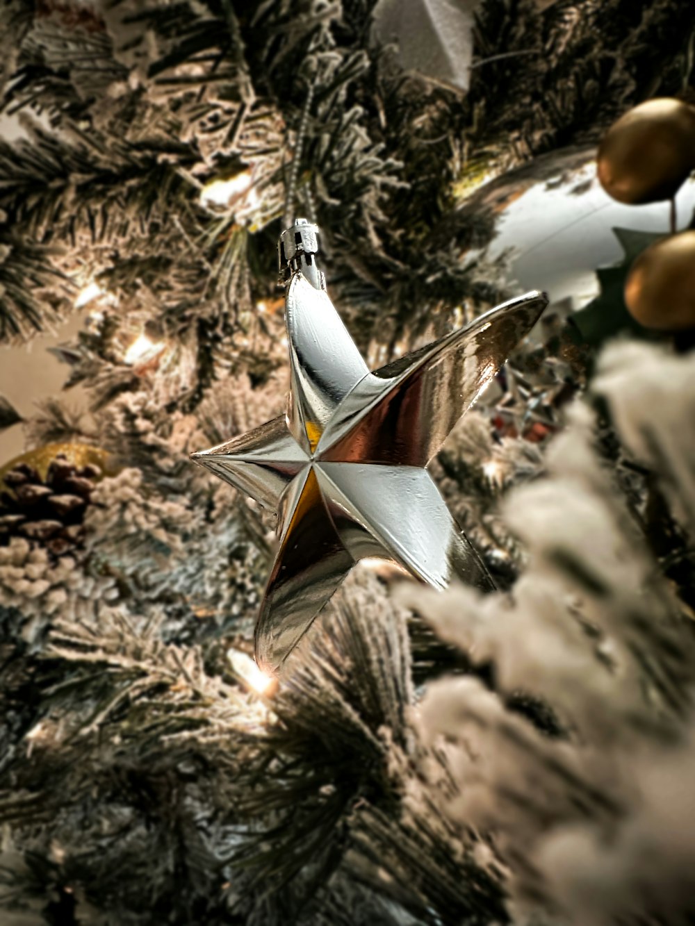a star ornament hanging from a christmas tree