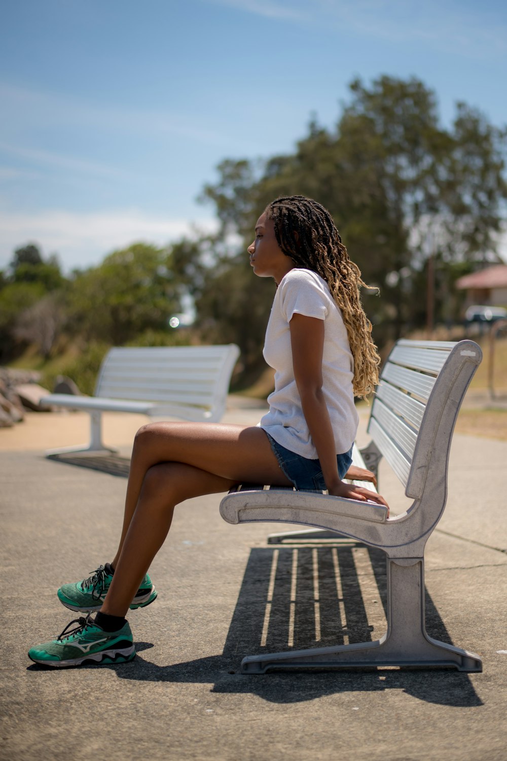 a woman sitting on a bench in a park