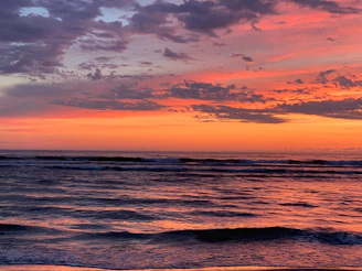 An ocean wave reflecting the colors of a stunning sunset.
