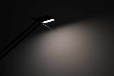 Simple black and white image of a minimalist lamp casting soft shadows.