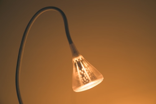 A sleek, modern eco-friendly home décor lamp glowing warmly in a cozy living room