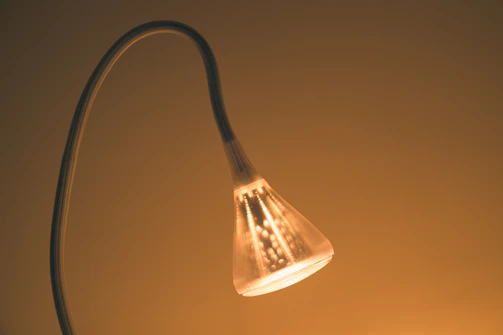 A designer lamp prototype made with 3D printing technology, glowing warmly in a modern setting.