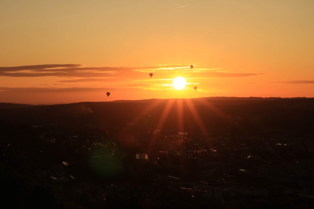 a sunset with hot air balloons in the sky