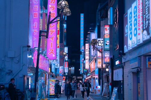 A vibrant street scene in Tokyo with colorful signs and bustling crowds.