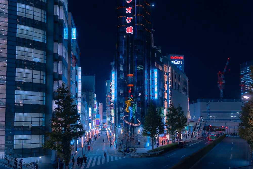 a city street at night with tall buildings