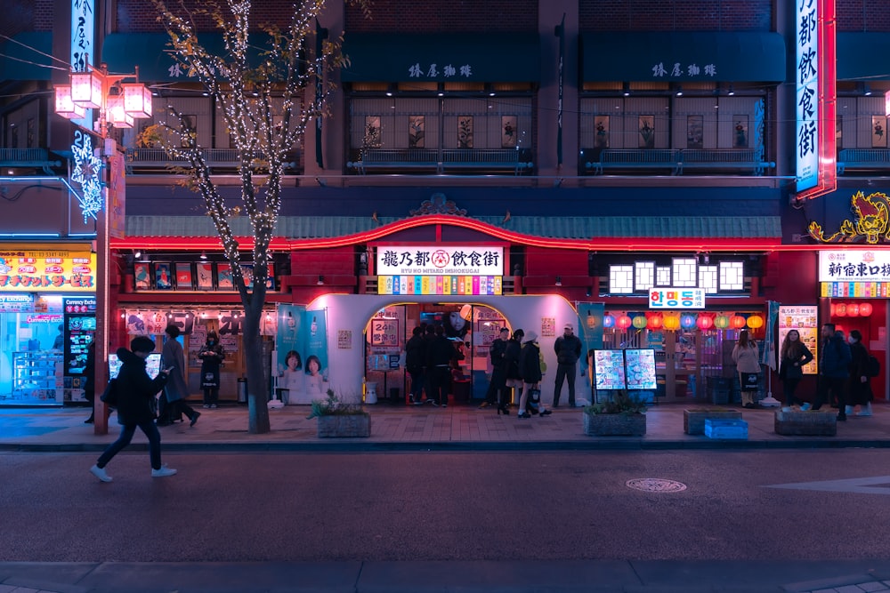 a group of people walking down a street at night