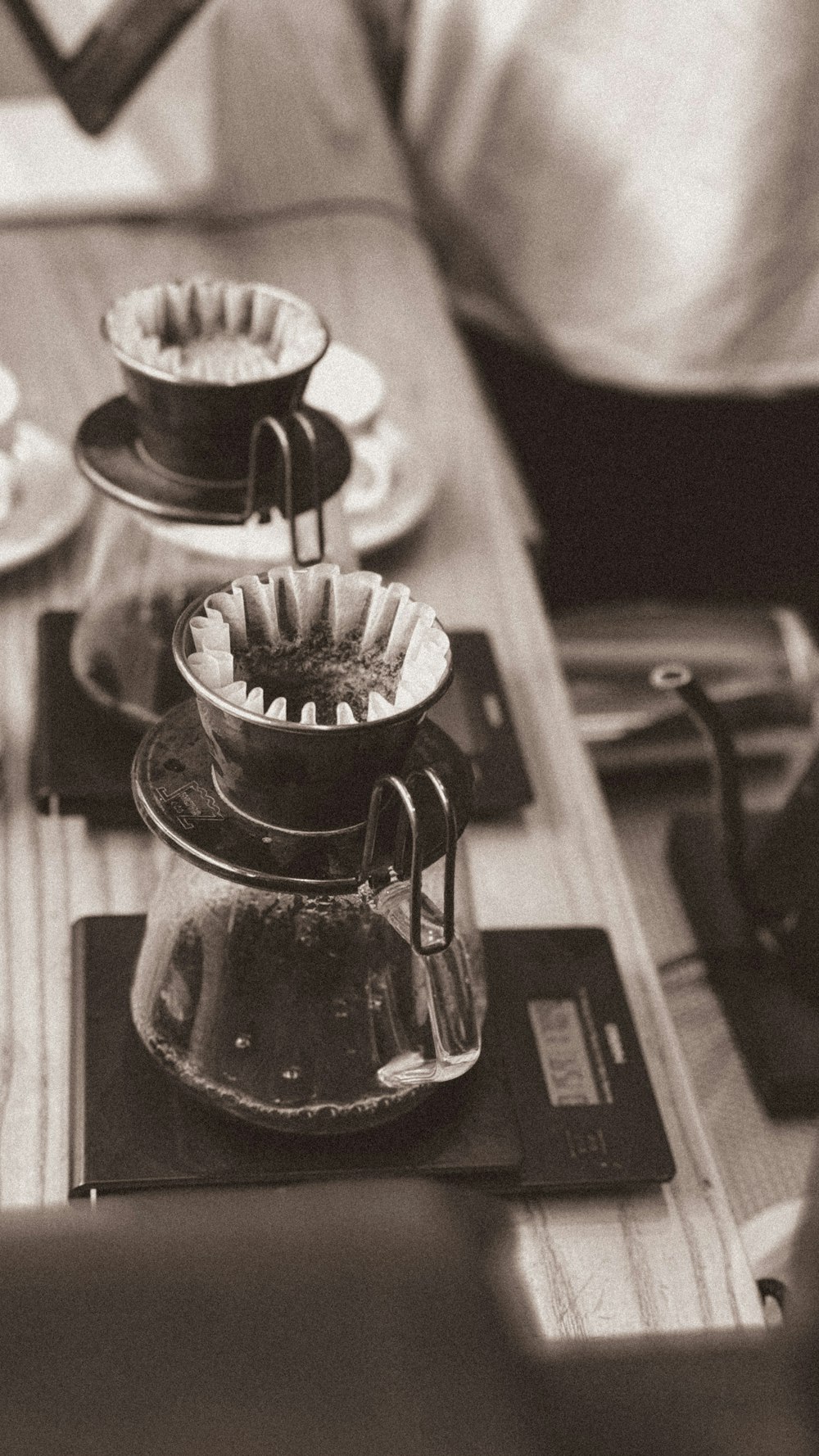 a wooden table topped with a coffee pot filled with liquid