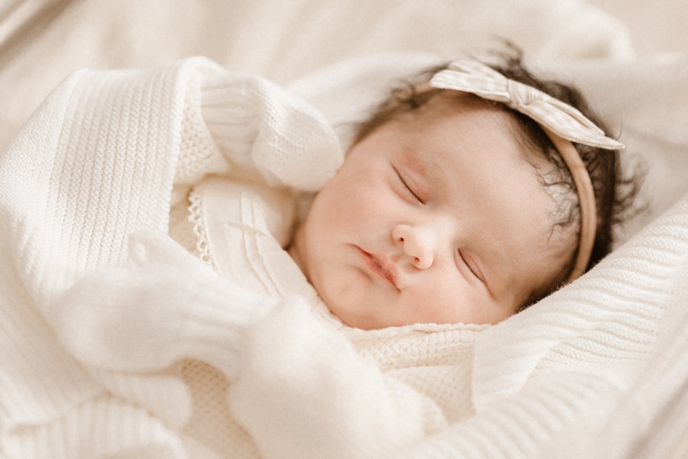 a baby is sleeping in a white blanket