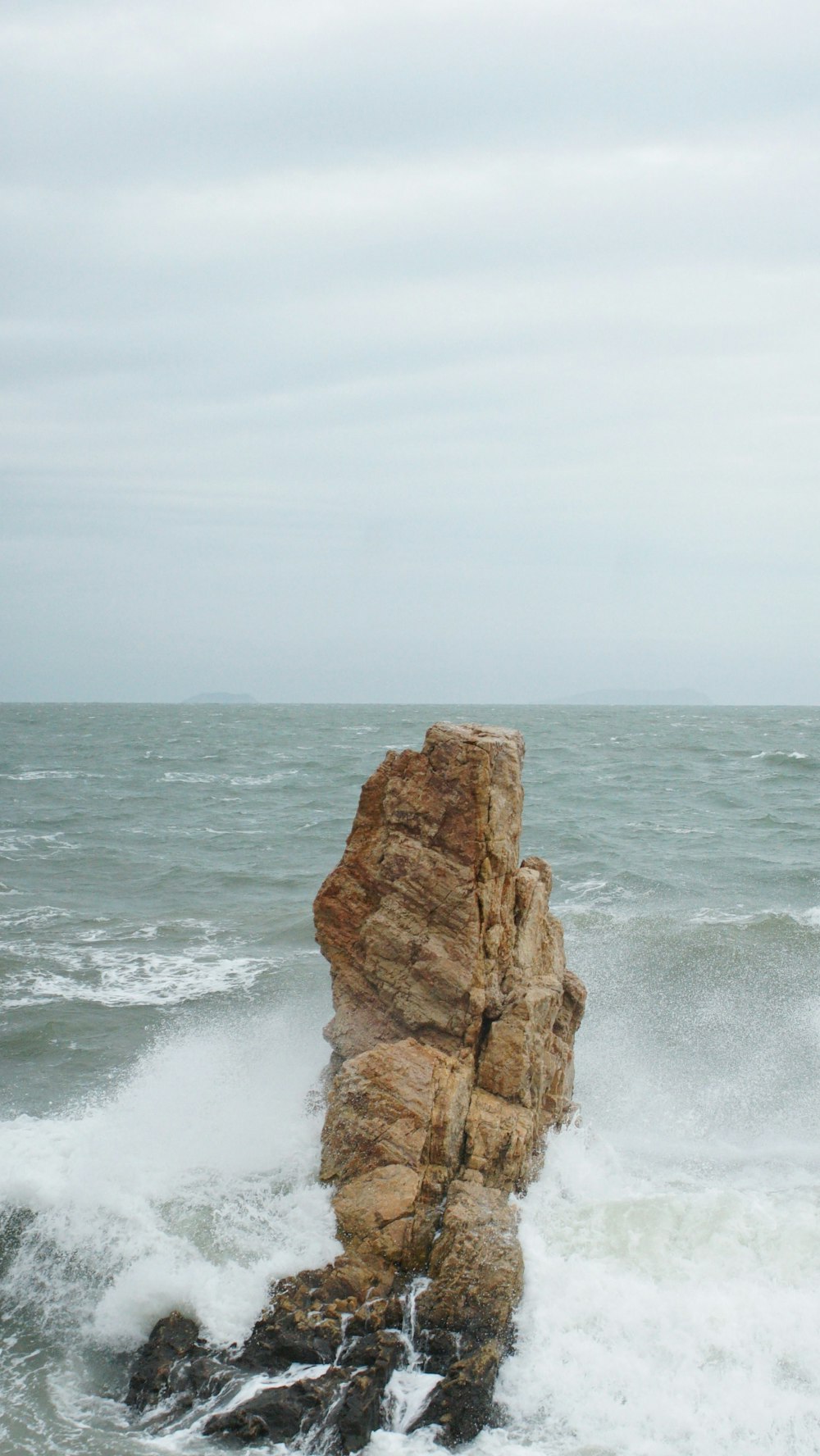 a large rock sticking out of the ocean