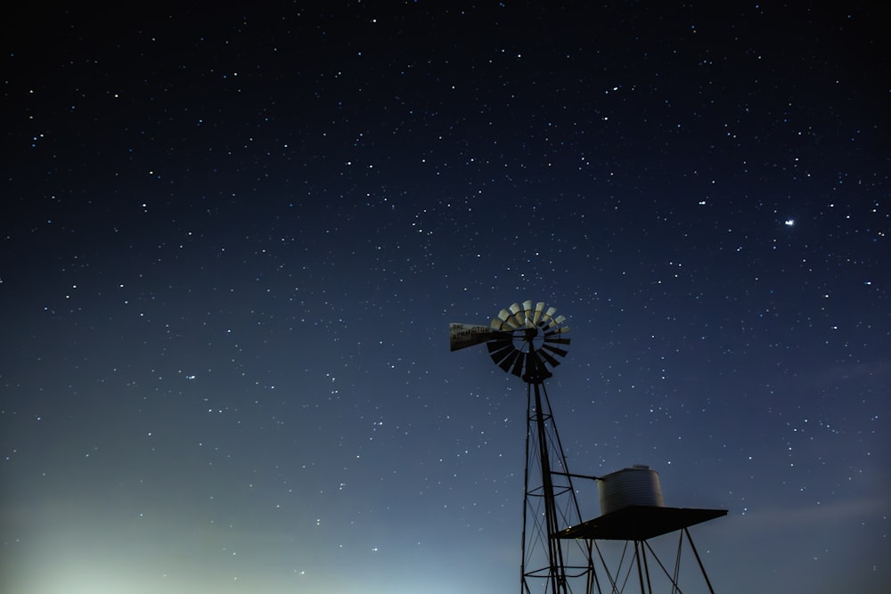 a windmill with a sky full of stars in the background
