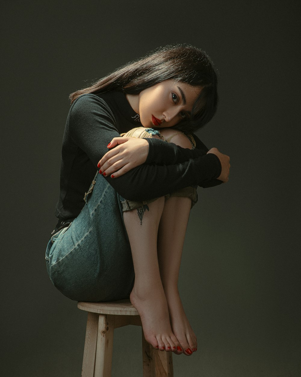 a woman sitting on top of a wooden stool