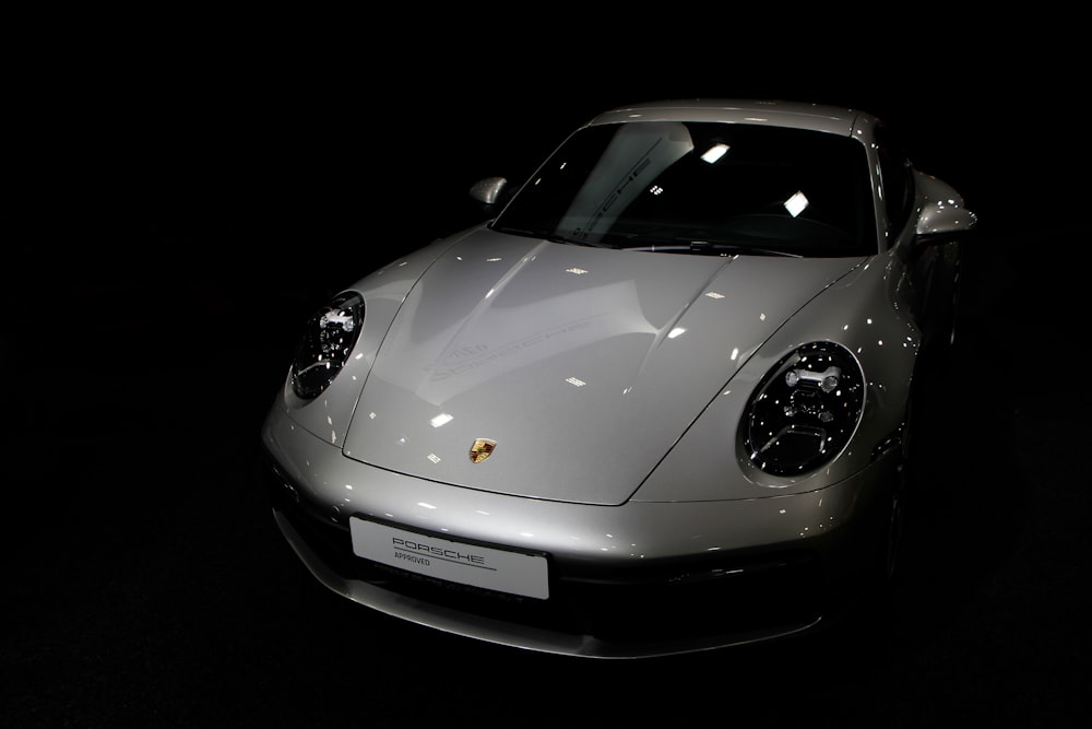 a white sports car parked in a dark room