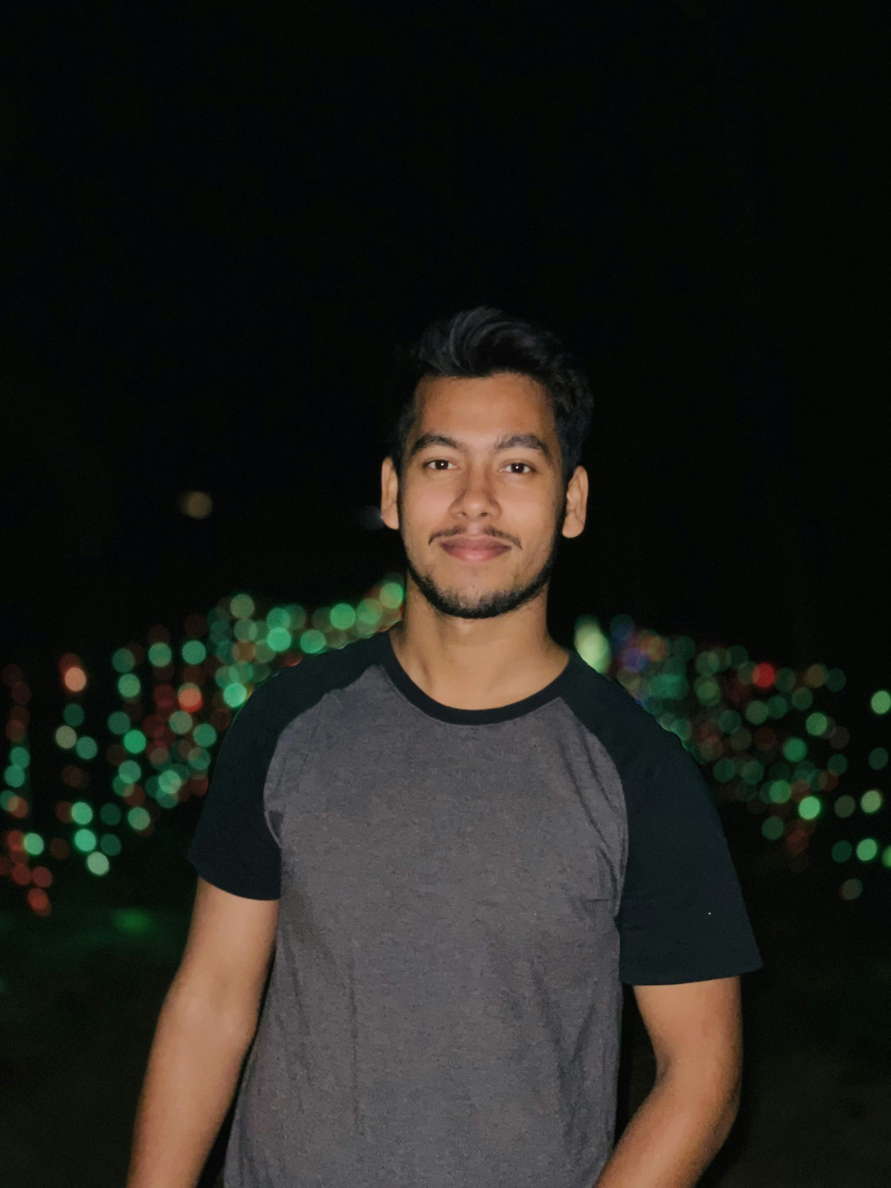 Seorang pria berdiri di depan pajangan lampu Natal