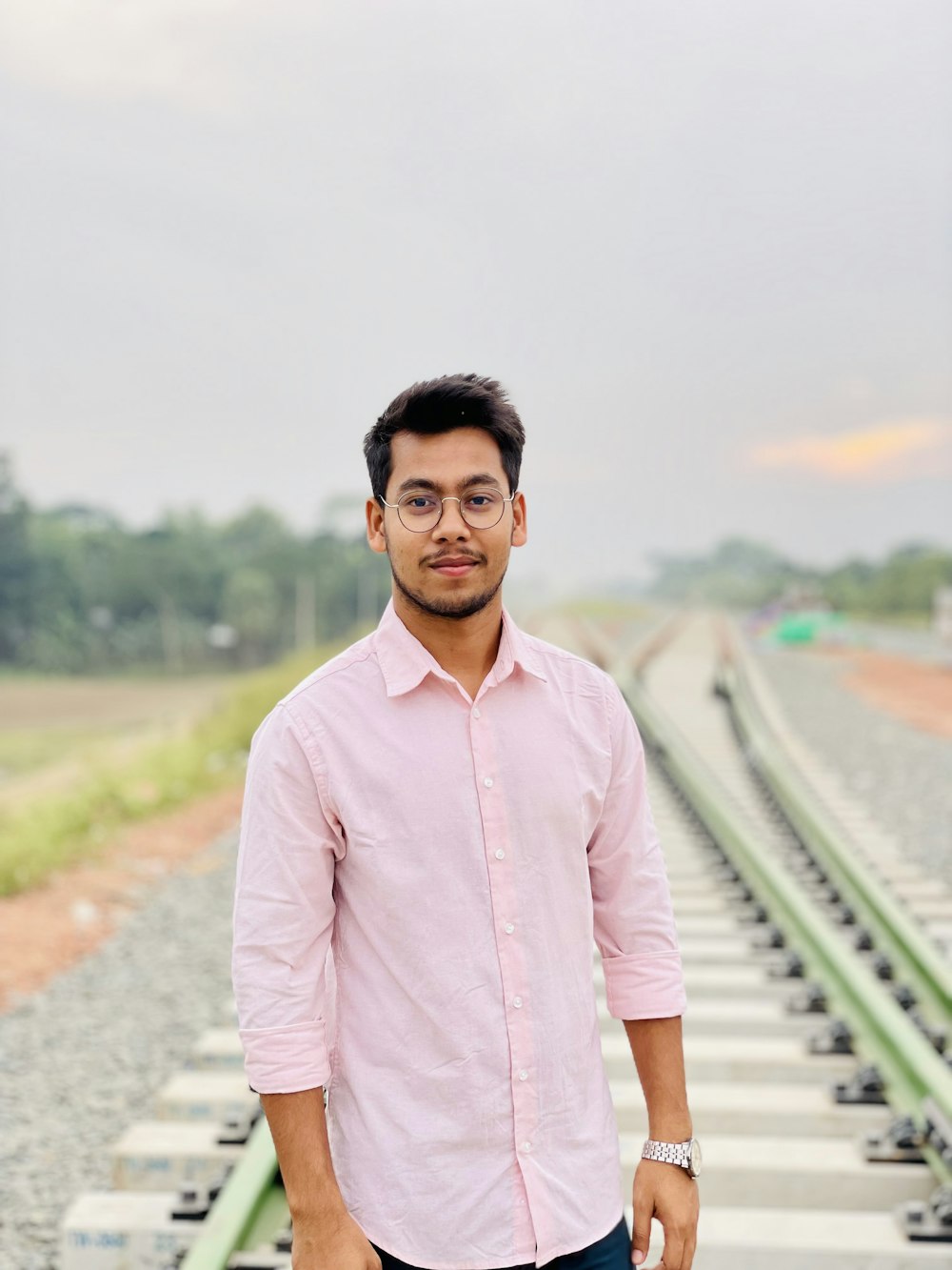 a man standing in front of a train track