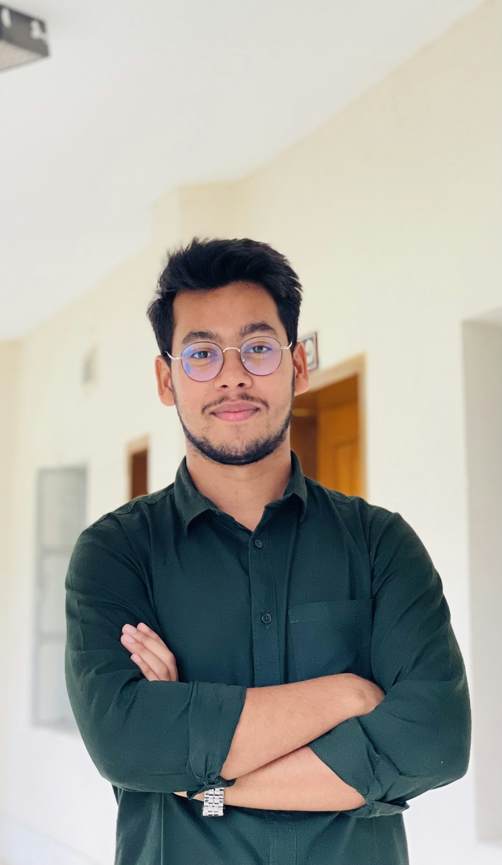 a man with glasses standing in a room