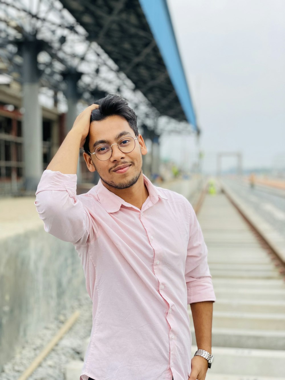 a man in a pink shirt is posing for a picture