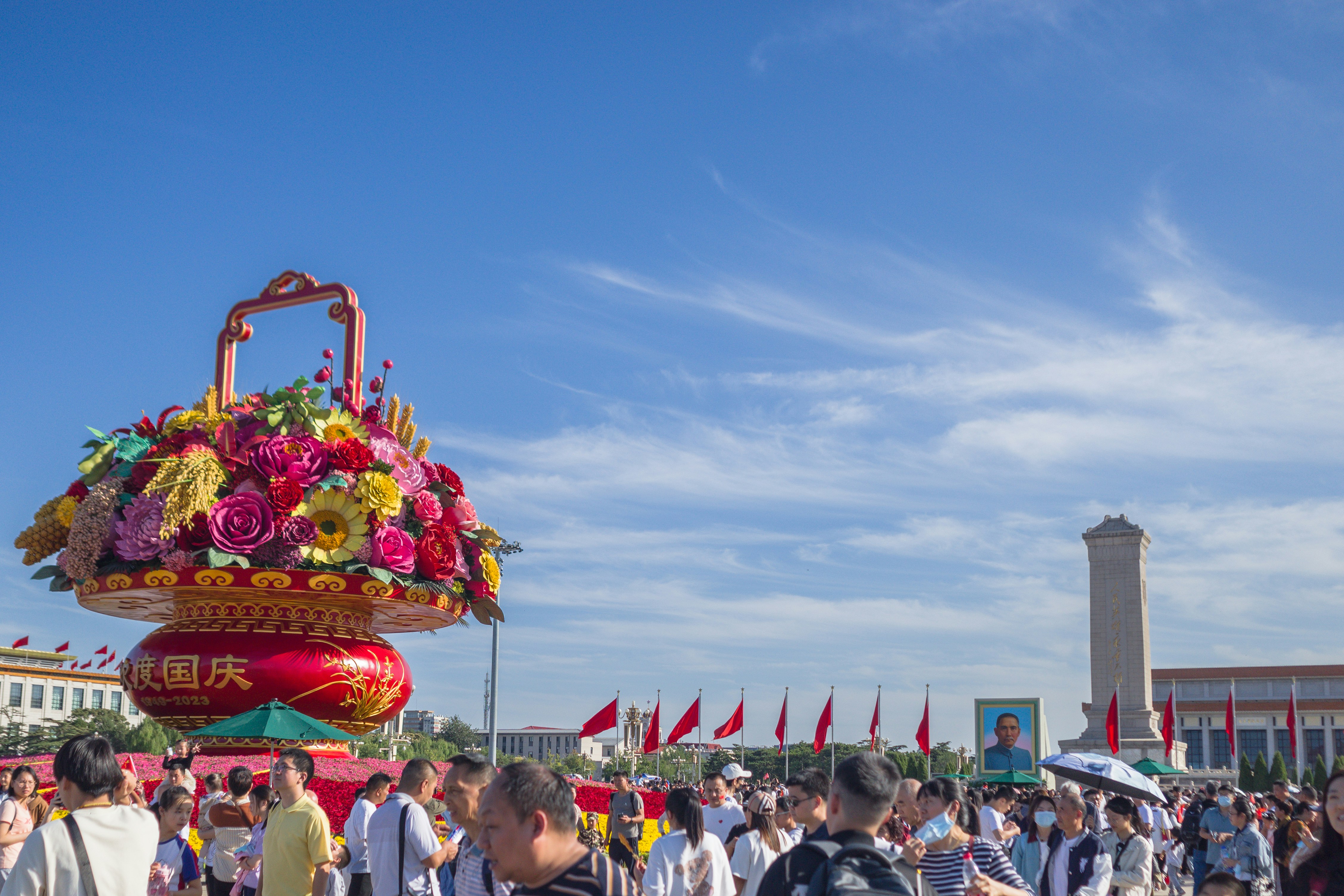 a group of people standing around a large basket of flowers, 