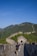 Smiling woman enjoying a guided tour in front of the Great Wall of China.