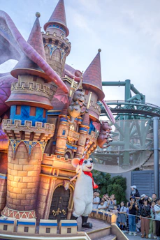 A playful Roblox-style scene showing a small castle and smiling characters waving hello.