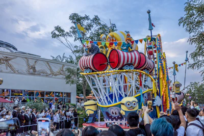 Colorful parade floats moving through the streets of Universal Orlando with excited visitors watching.